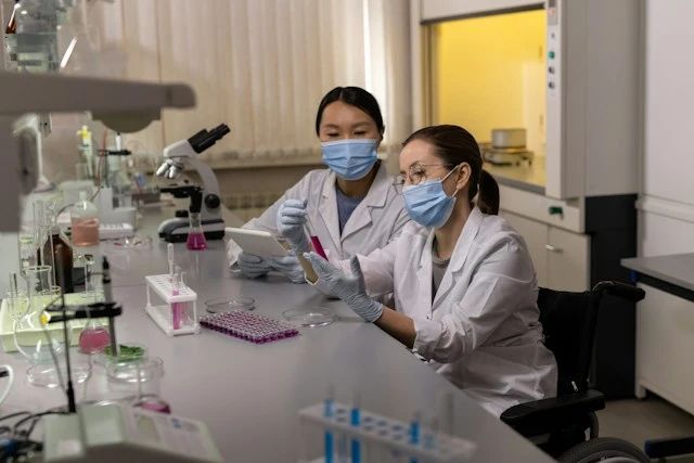 Doctor in a white coat talking with a patient seated on an exam table